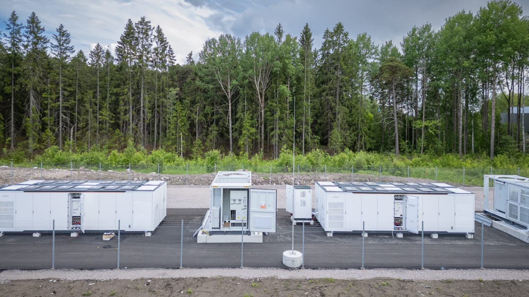 Gaavle_site1 Battery energy storage systems developed by Ingrid Capacity at a site in Sweden surrounded by green trees.